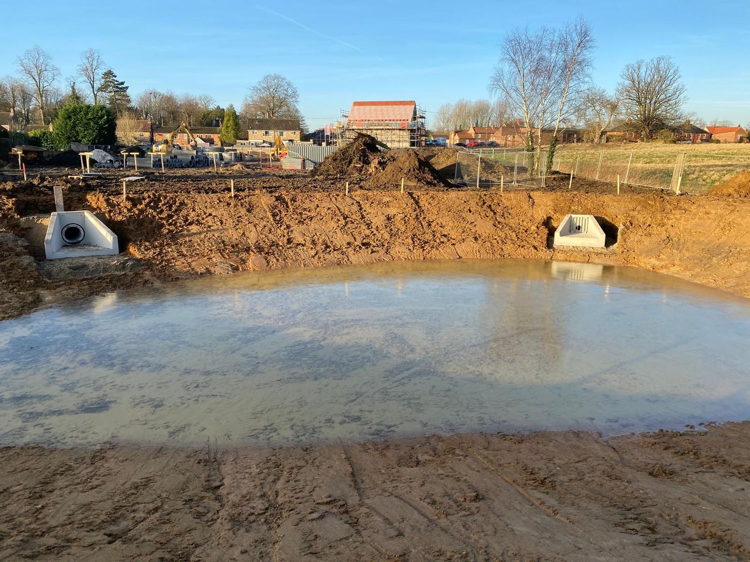Attenuation pond holding water with both headwalls in place