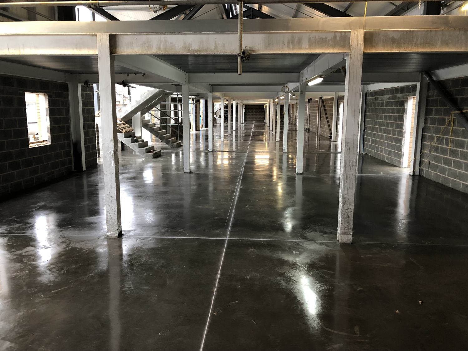 Power-floated concrete floor beneath a mezzanine